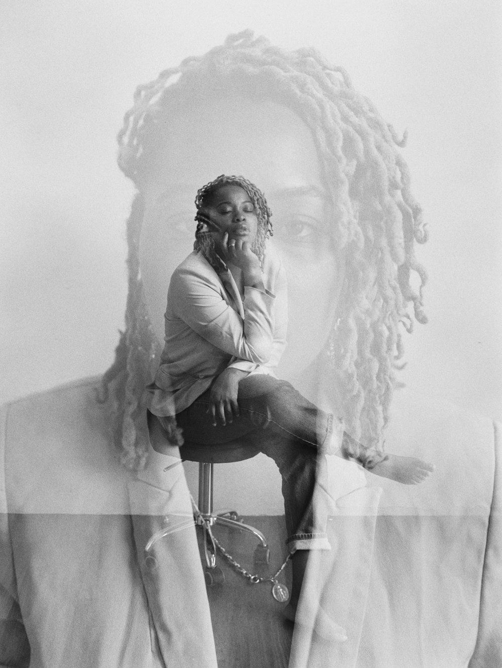 a black and white photo of a man with dreadlocks