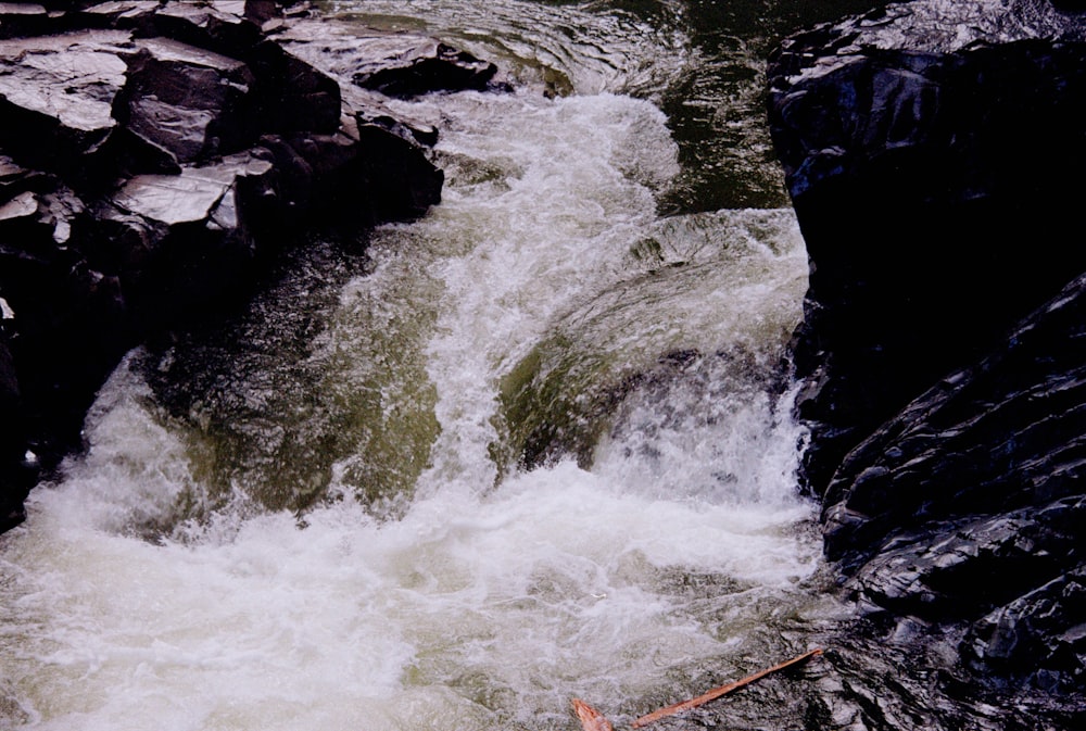 a man riding a surfboard on top of a river