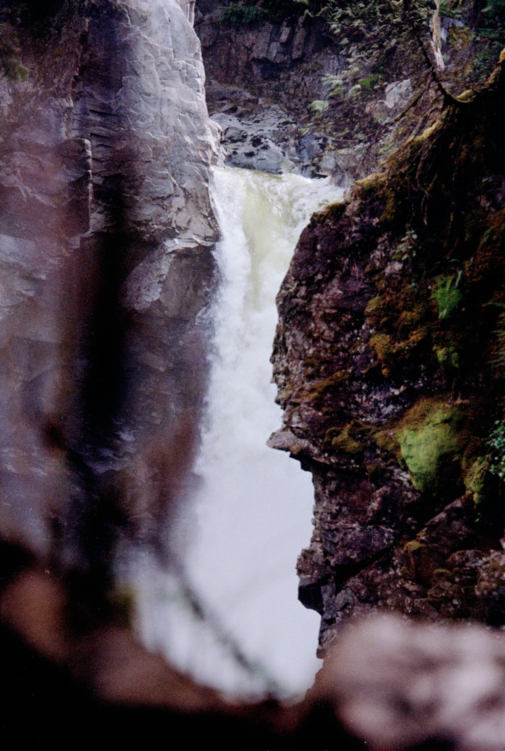 a view of a waterfall from the side of a cliff