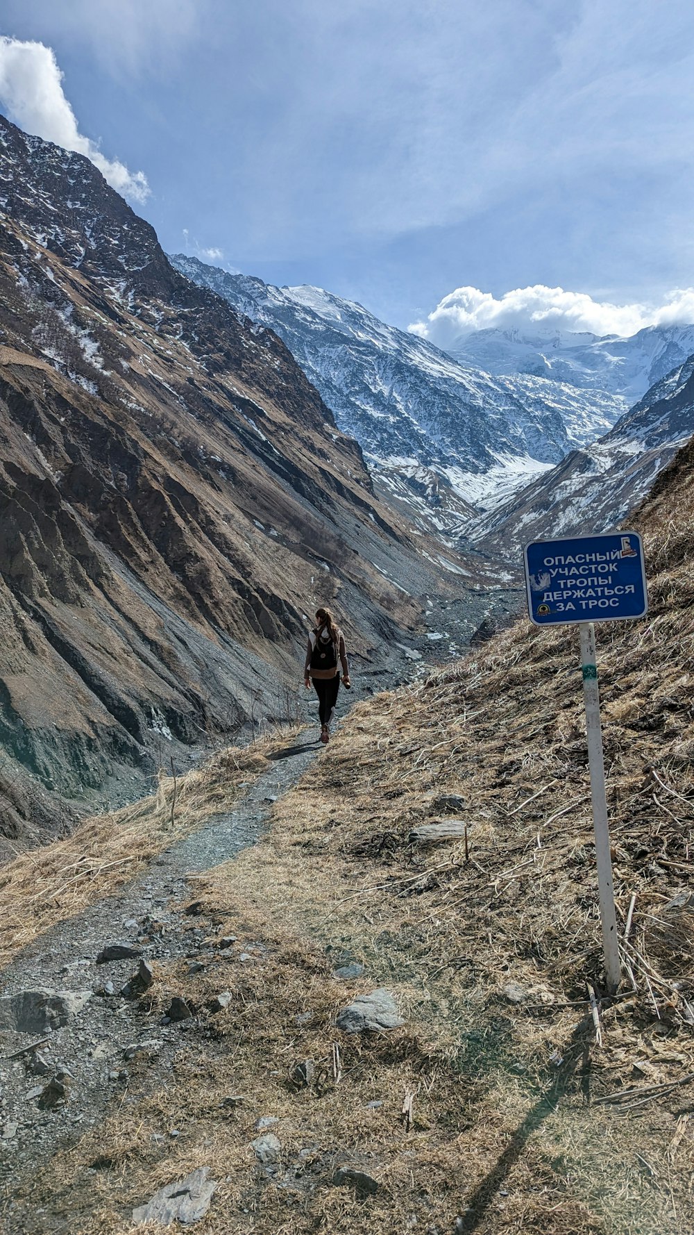 a man walking down a trail in the mountains