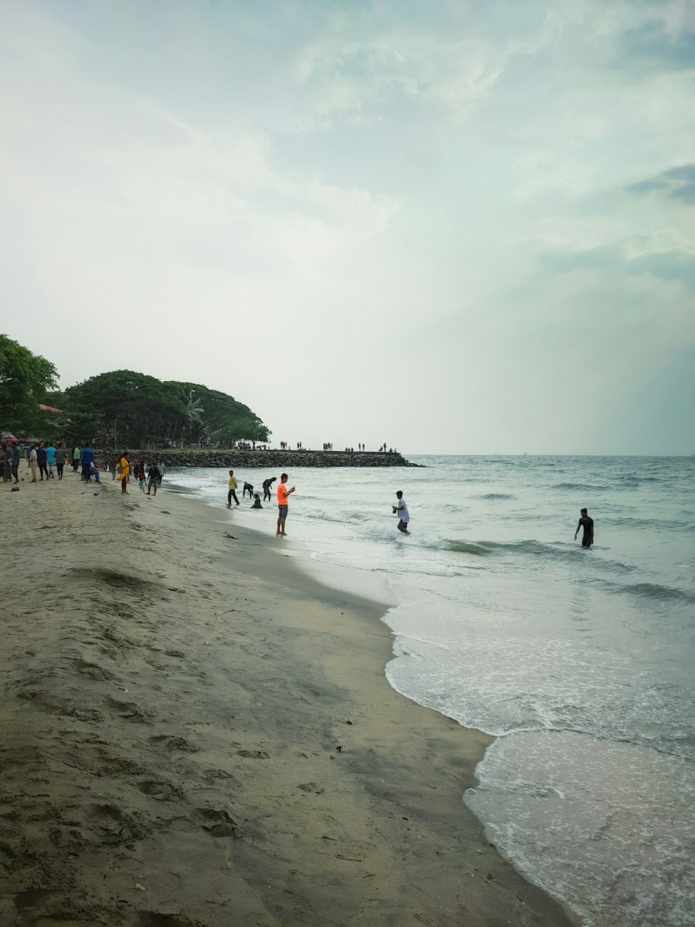 a group of people standing on top of a sandy beach