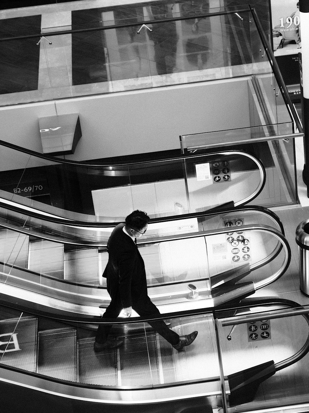 a man in a suit walking down an escalator