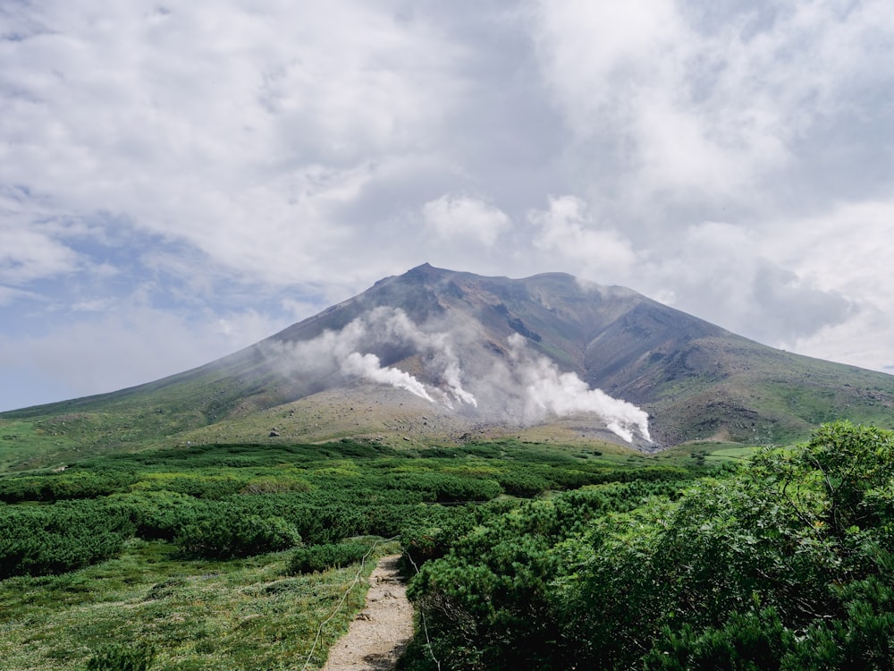 a mountain covered in mist and clouds on a cloudy day