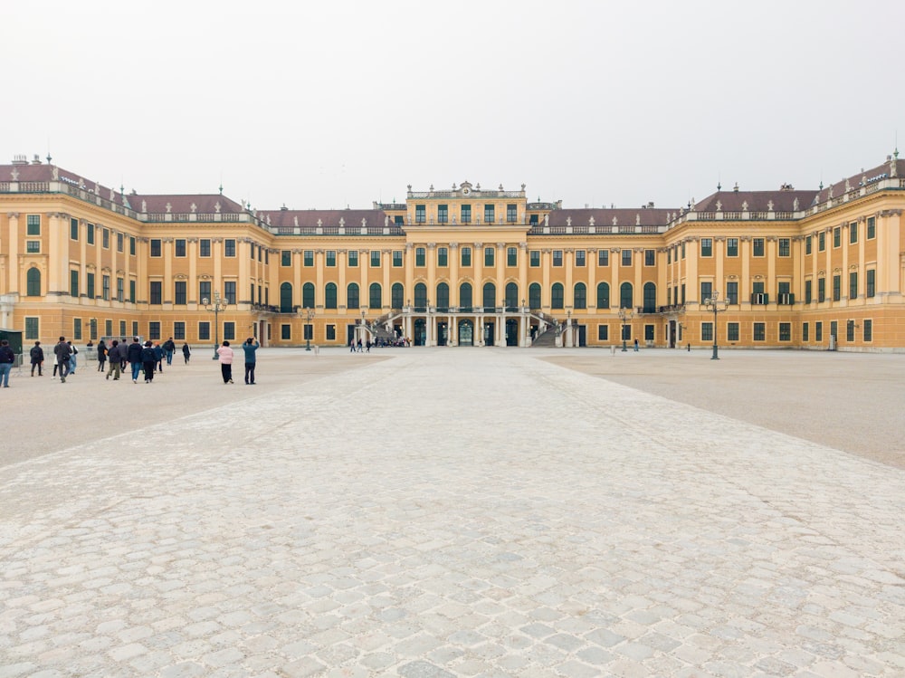 a large yellow building with people walking around it