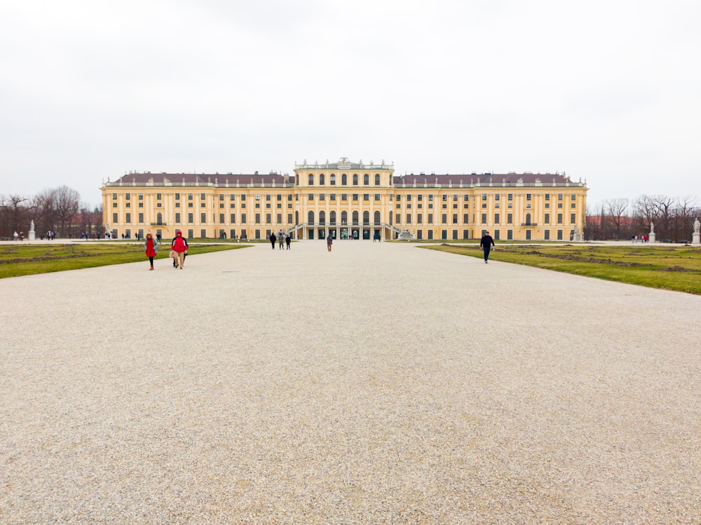 a group of people walking in front of a large building