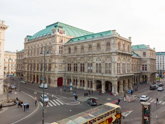a double decker bus driving down a street next to a tall building