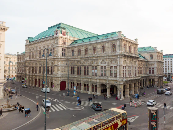 a double decker bus driving down a street next to a tall building