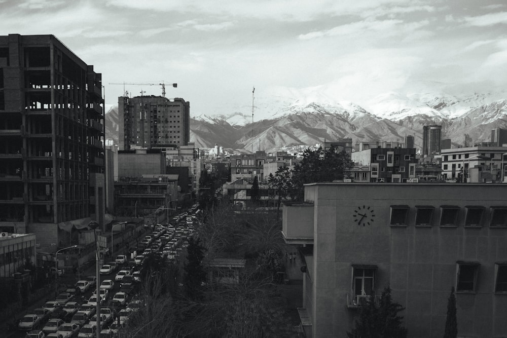 a black and white photo of a city with mountains in the background