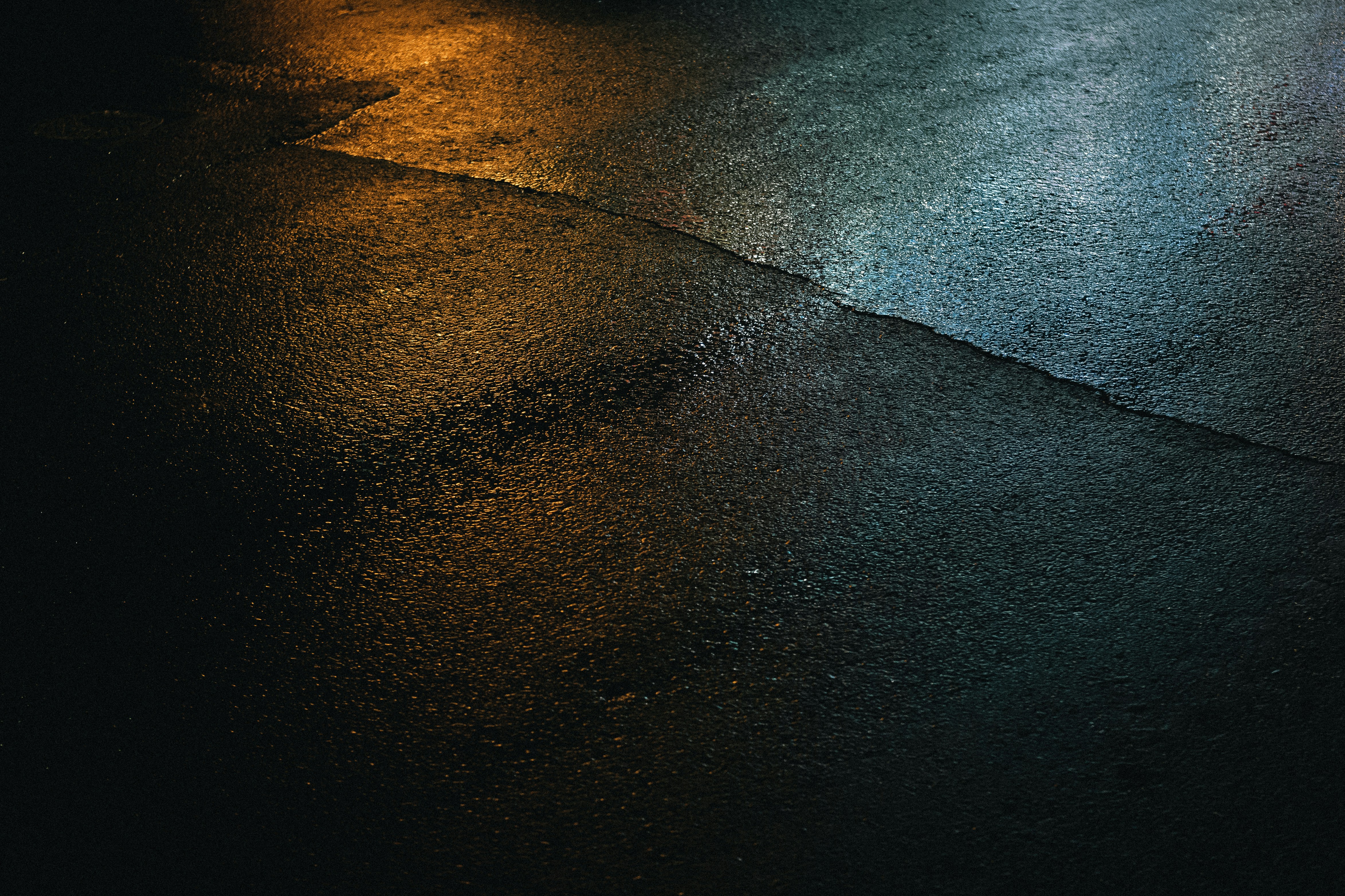 a wet street with a street light in the background