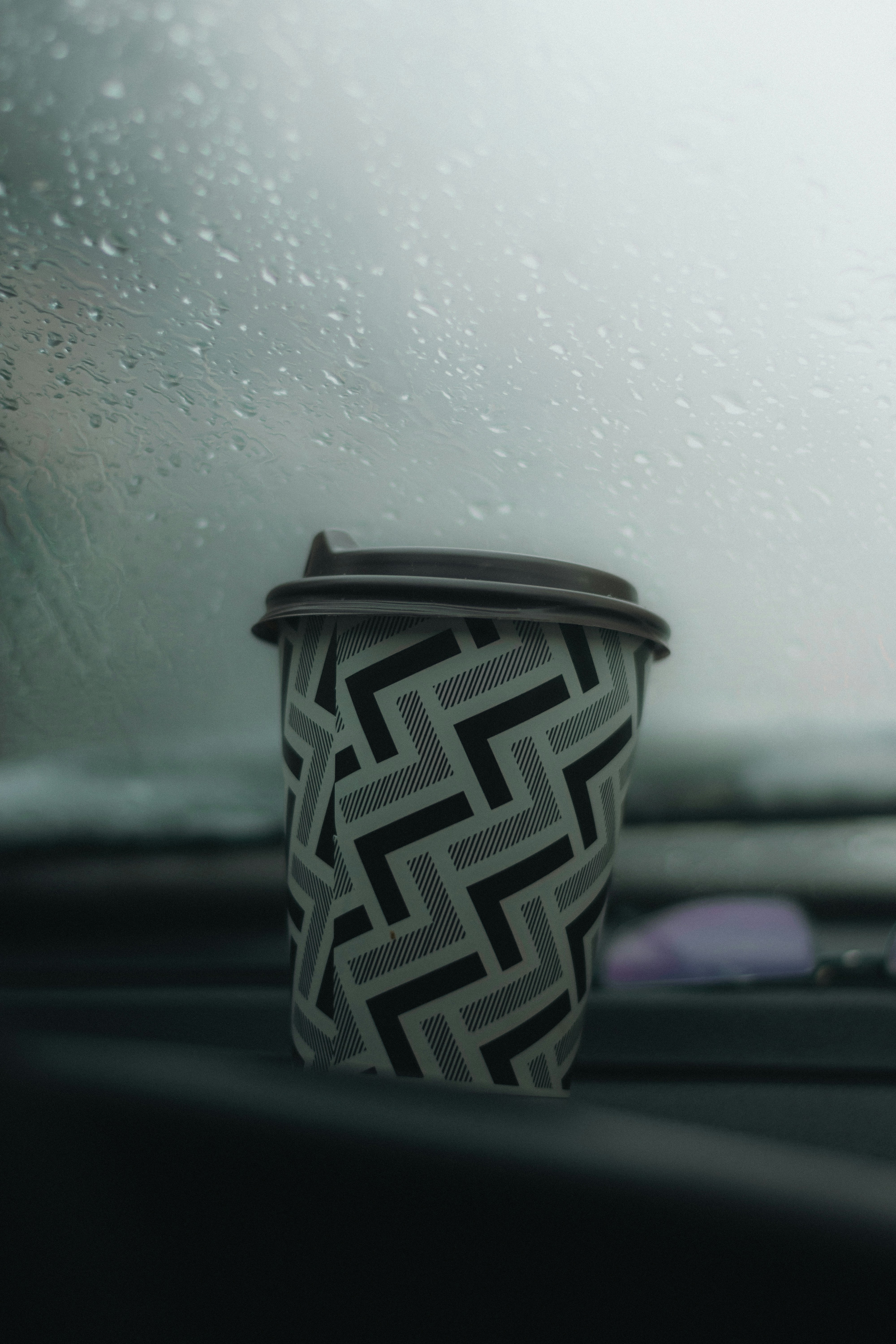 a cup of coffee sitting on the dashboard of a car