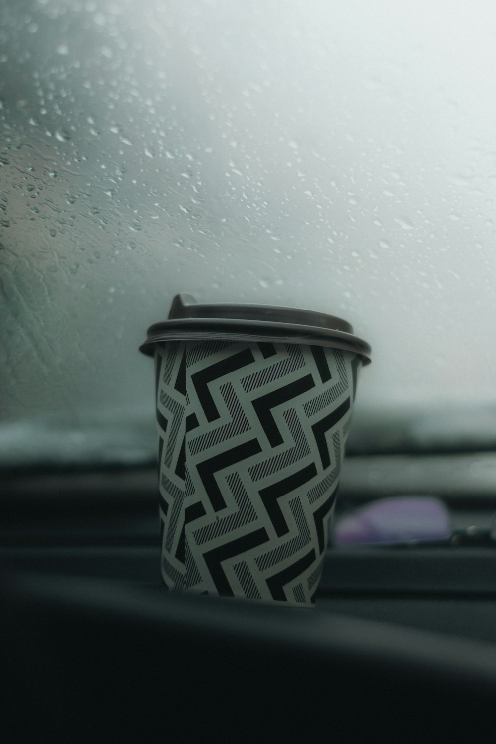 a cup of coffee sitting on the dashboard of a car