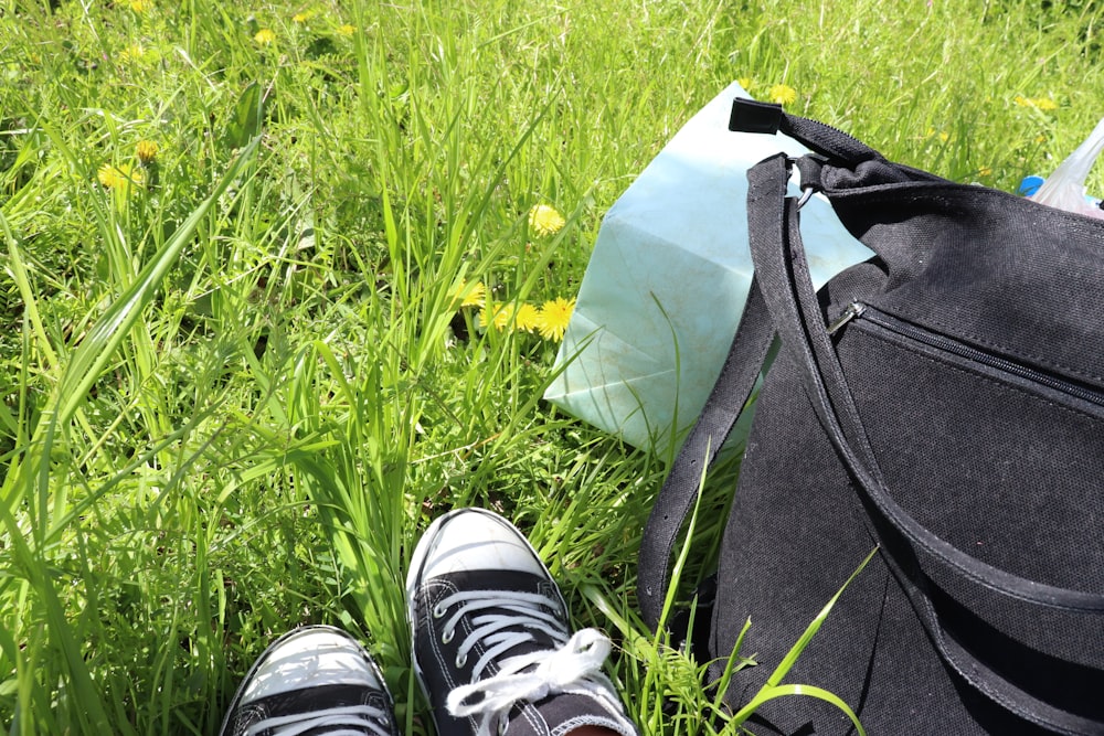 a pair of sneakers and a bag sitting in the grass