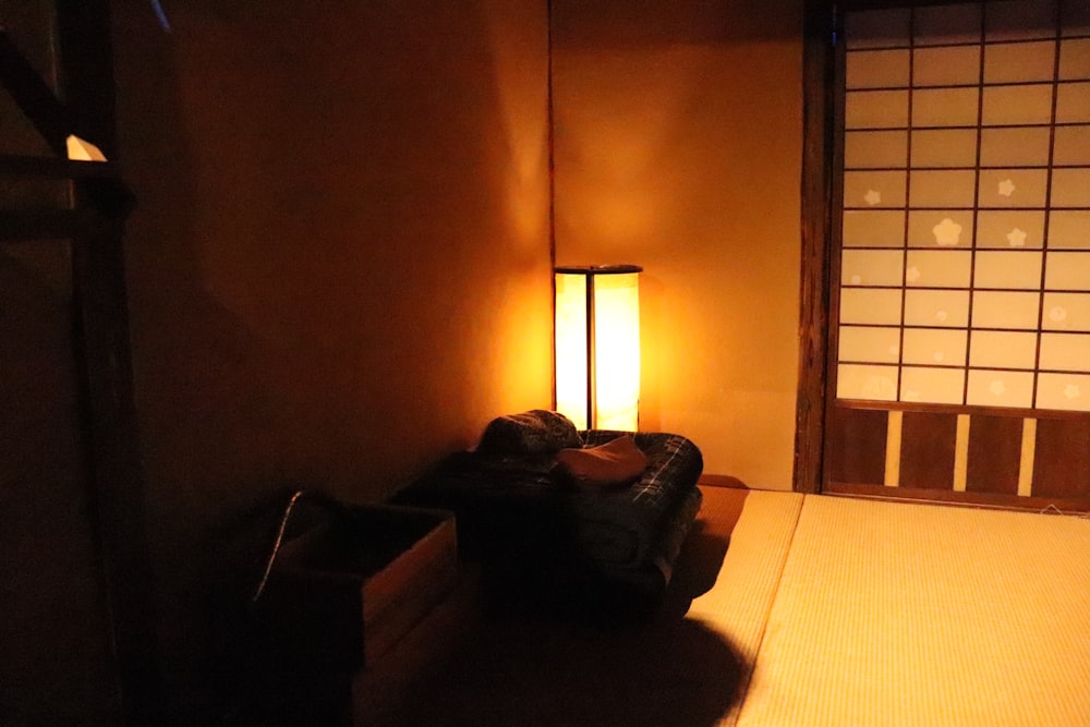 una maleta sentada en una cama en una habitación con poca luz