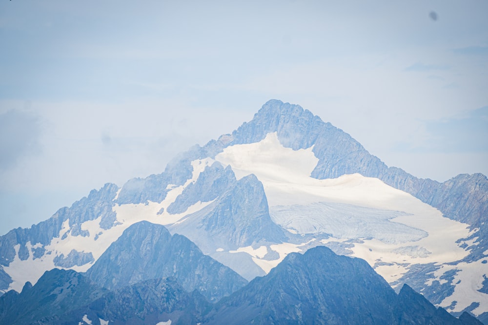 a snow covered mountain with a bird flying over it