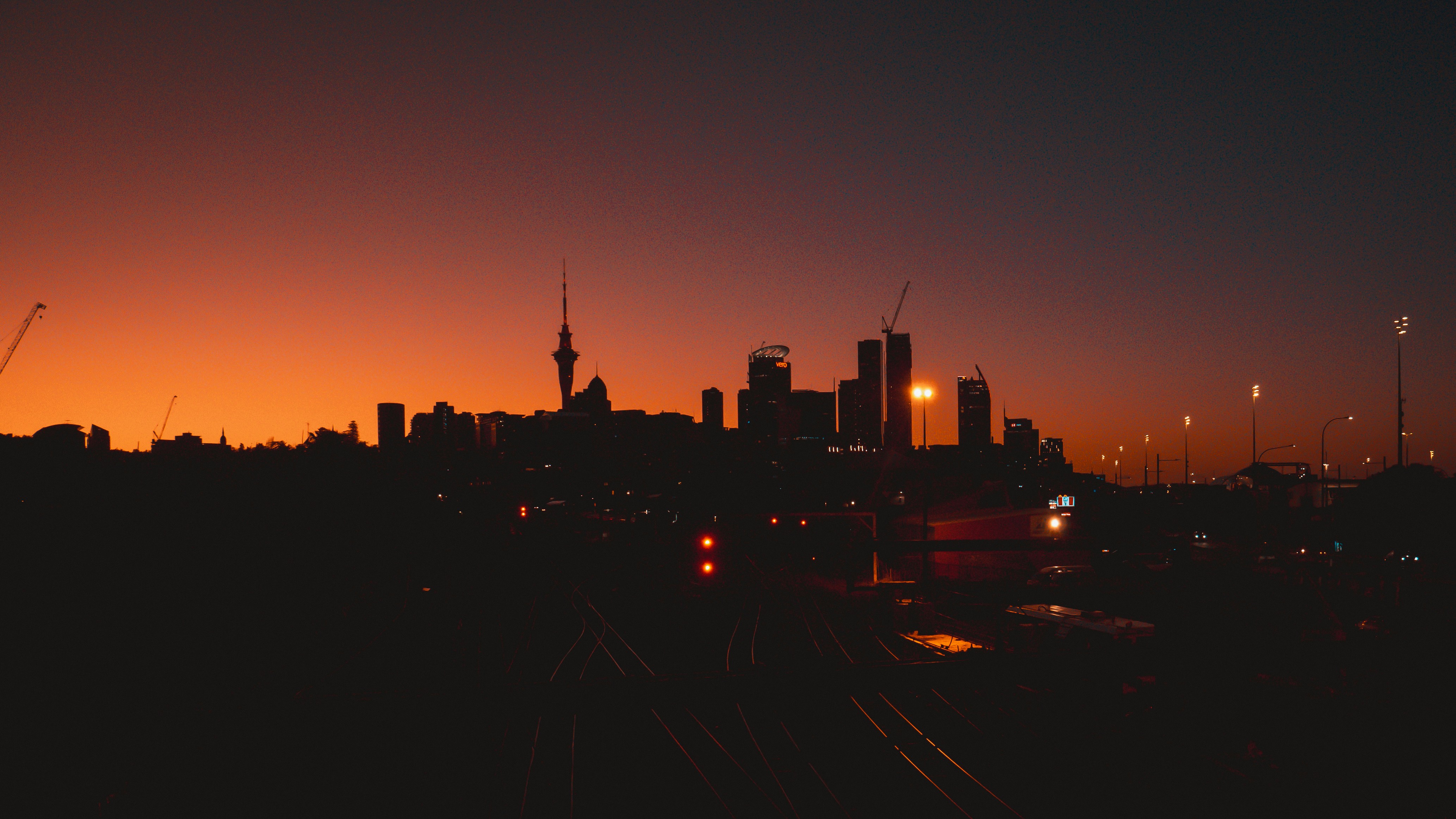 a city skyline at night with a train on the tracks, Auckland City Sunset
