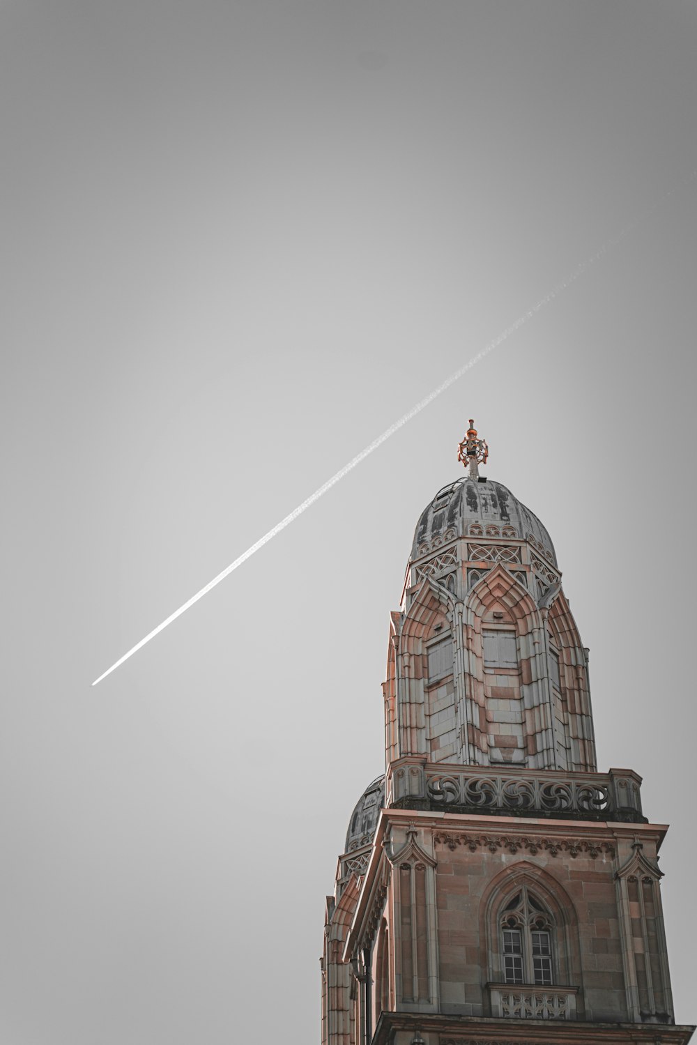 an airplane flying over a building with a steeple