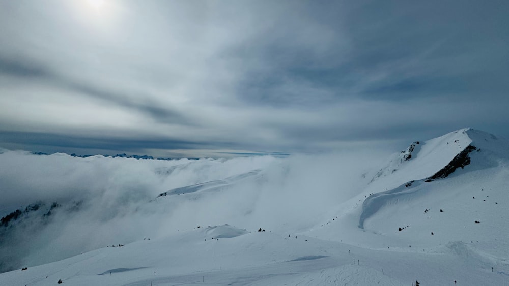 a mountain covered in snow under a cloudy sky