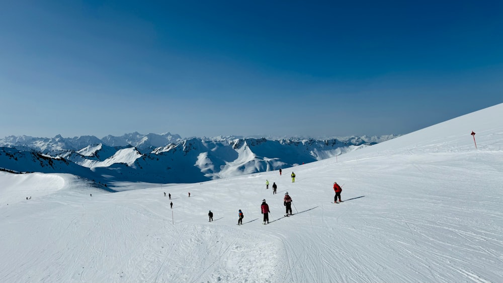 a group of people skiing down a snow covered slope