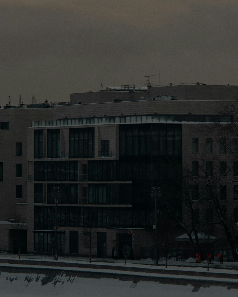 an airplane flying over a building in the snow