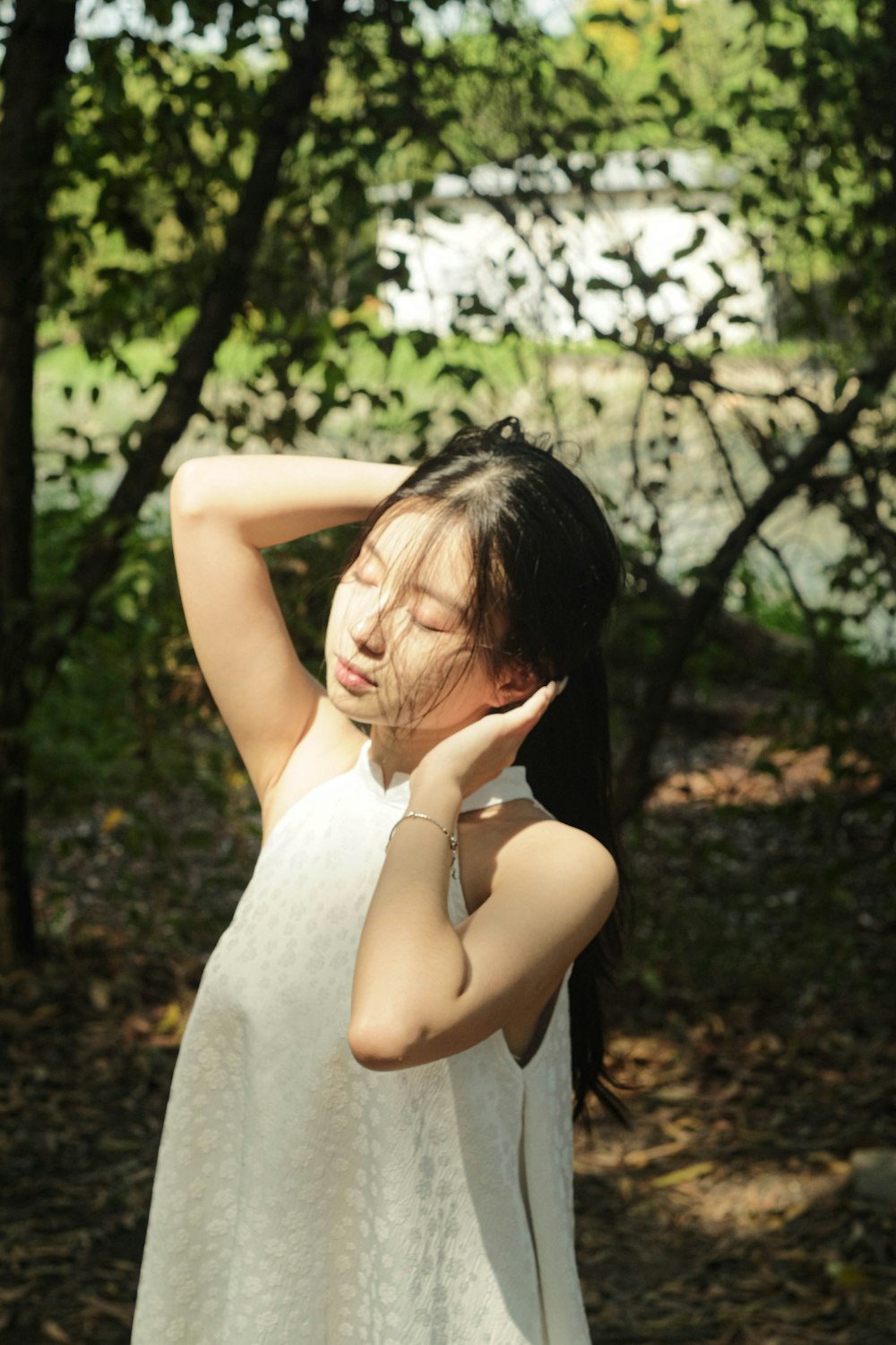 a woman in a white dress holding her head