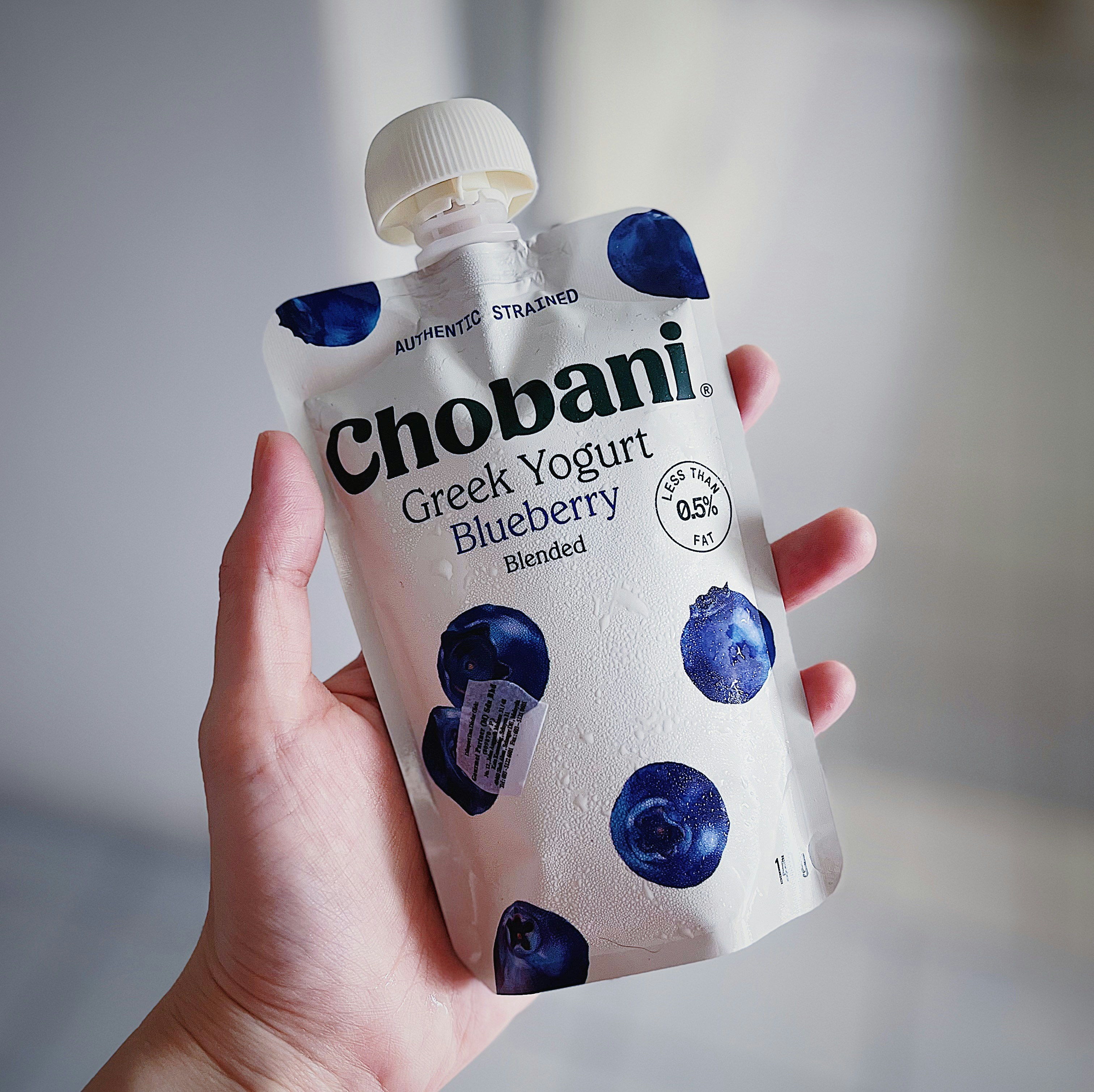 A hand holding a bottle of chobani greek yogurt blueberry photo - Free ...