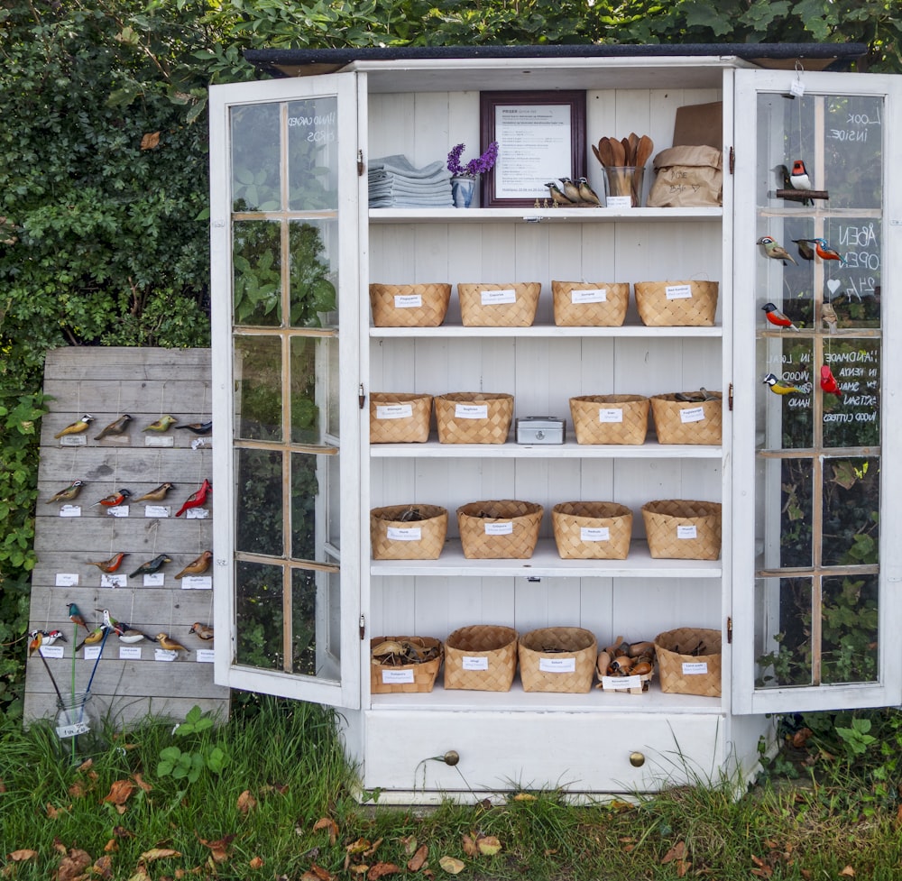 a white cabinet filled with lots of baskets