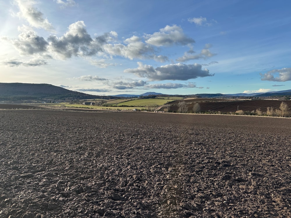 a large open field with a sky in the background