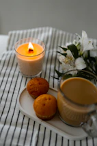 a plate with muffins and a candle on a table