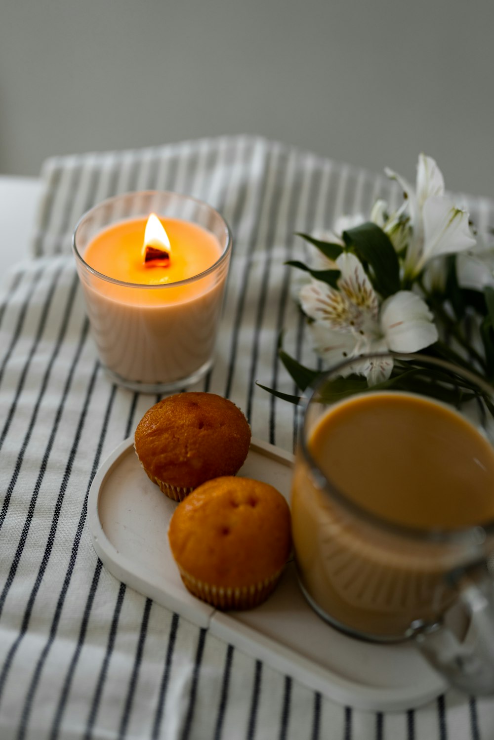 a plate with muffins and a candle on a table