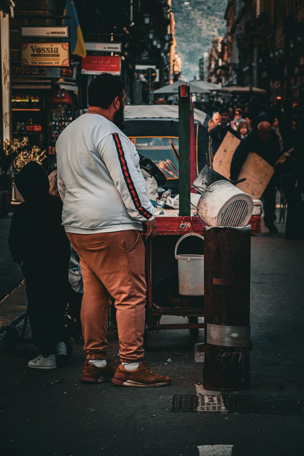 a man standing in front of a machine on a city street