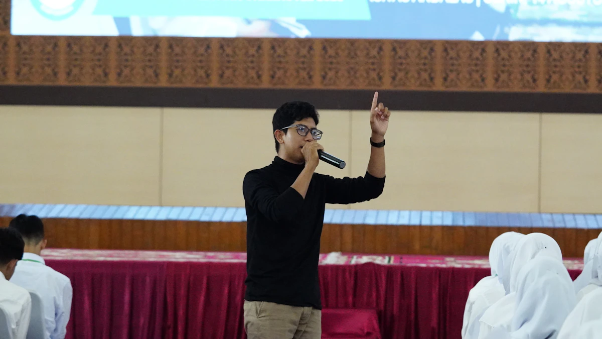 A speaker with a microphone leading an interactive public speaking workshop for a group