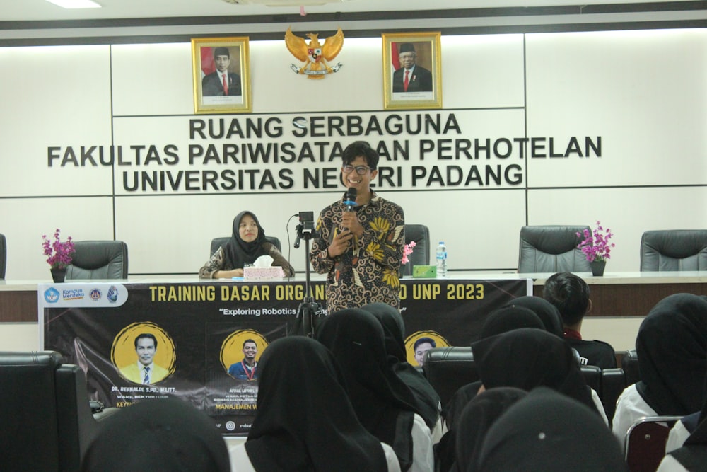 a woman standing at a podium in front of a group of people