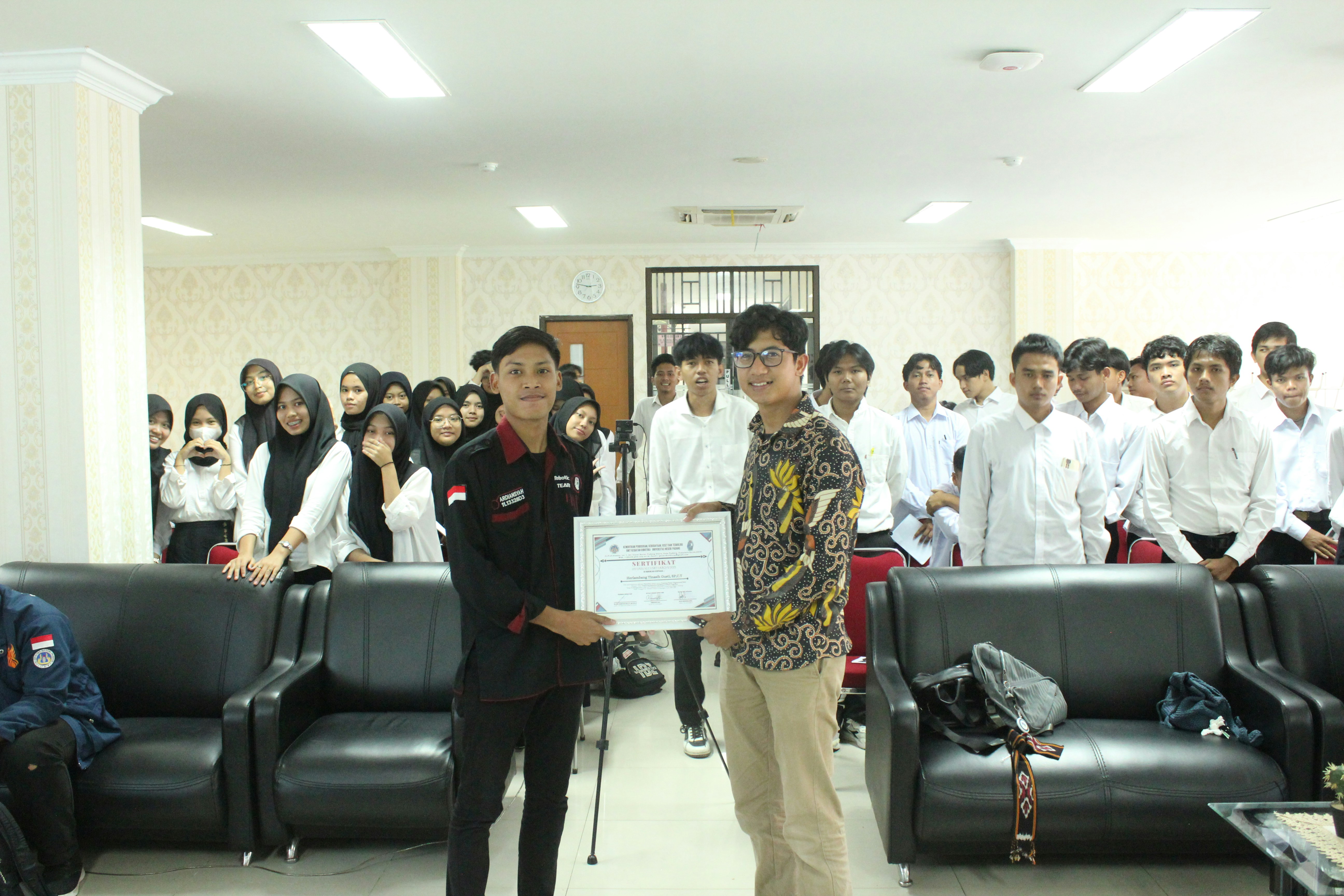 Seorang siswa menerima piala penghargaan.