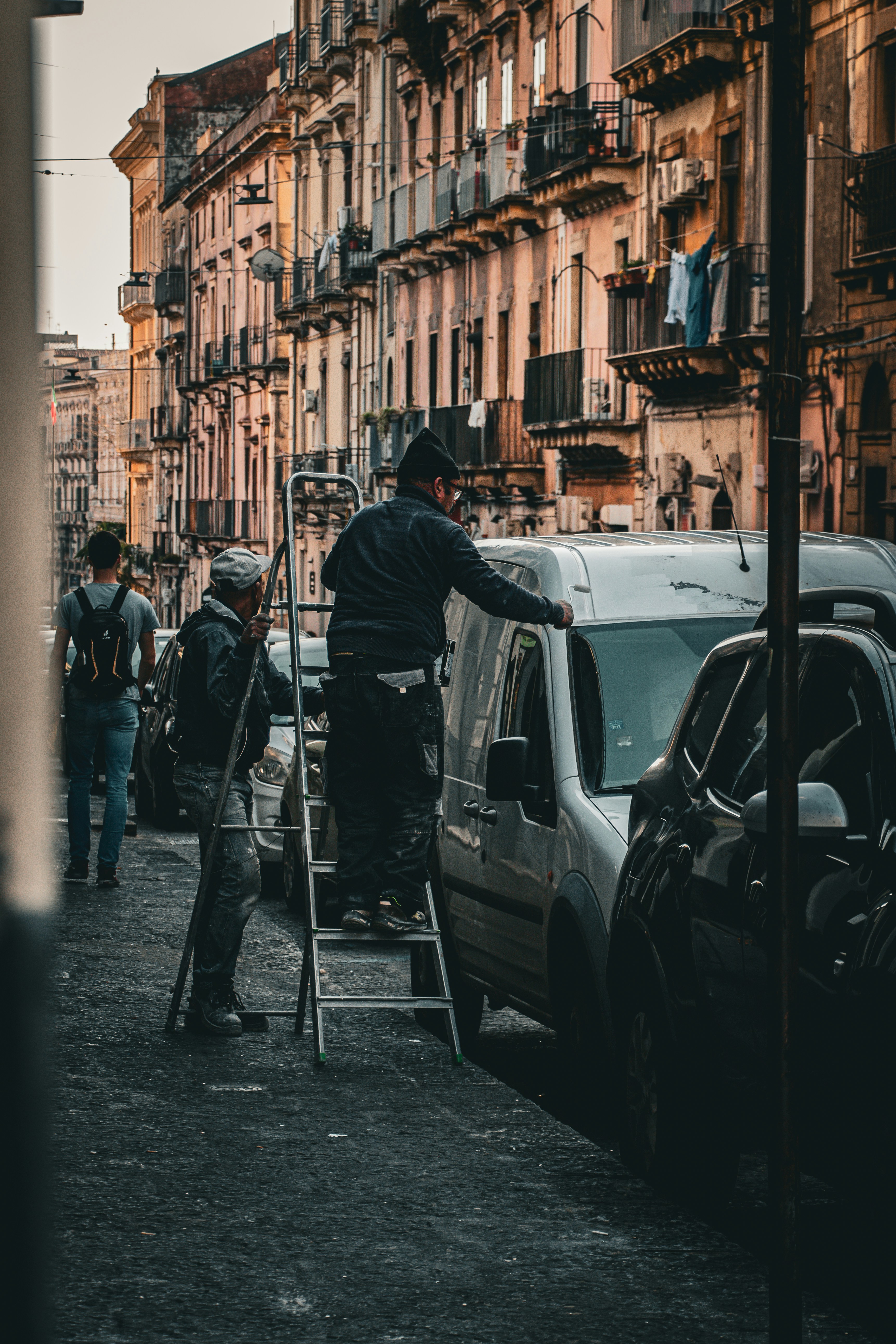 a man is painting a building on the side of a street