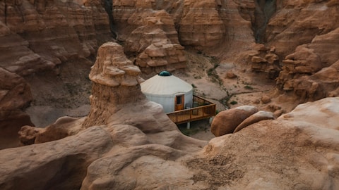 a yurt in the middle of a canyon surrounded by rocks