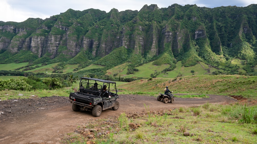 a couple of people riding on the back of four wheelers