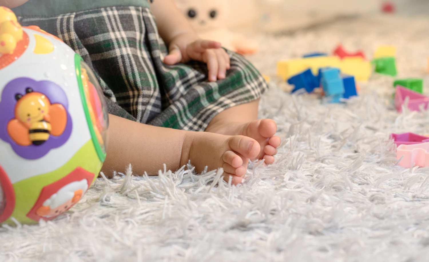 A child's hands playing in a bowl of colorful sensory materials