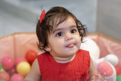 a little girl sitting in a ball pit