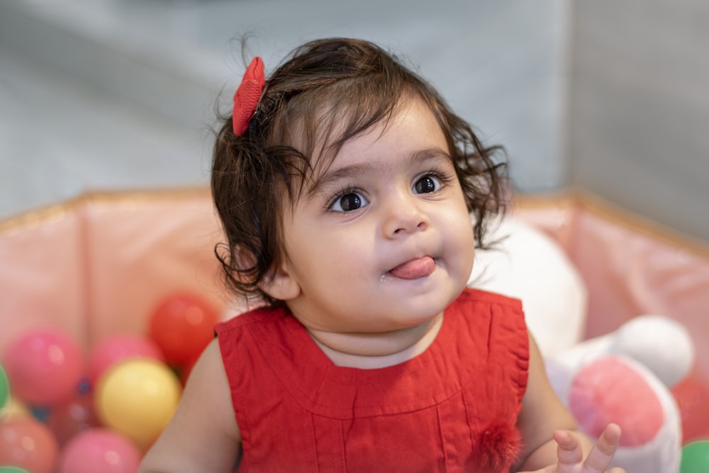 a little girl sitting in a ball pit