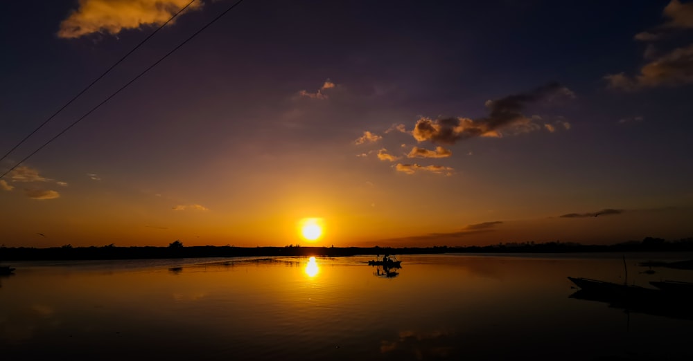 a sunset over a body of water with boats in the water