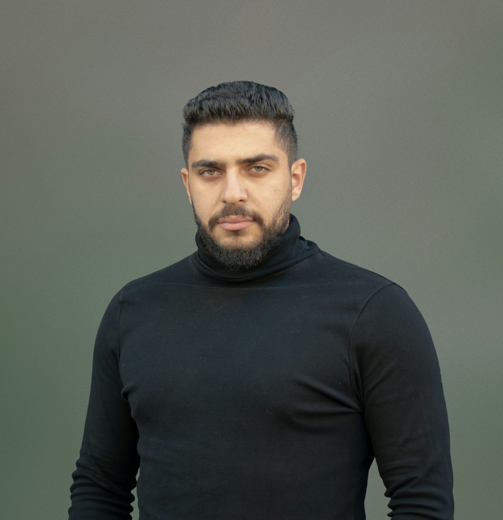 a man wearing a black turtle neck sweater