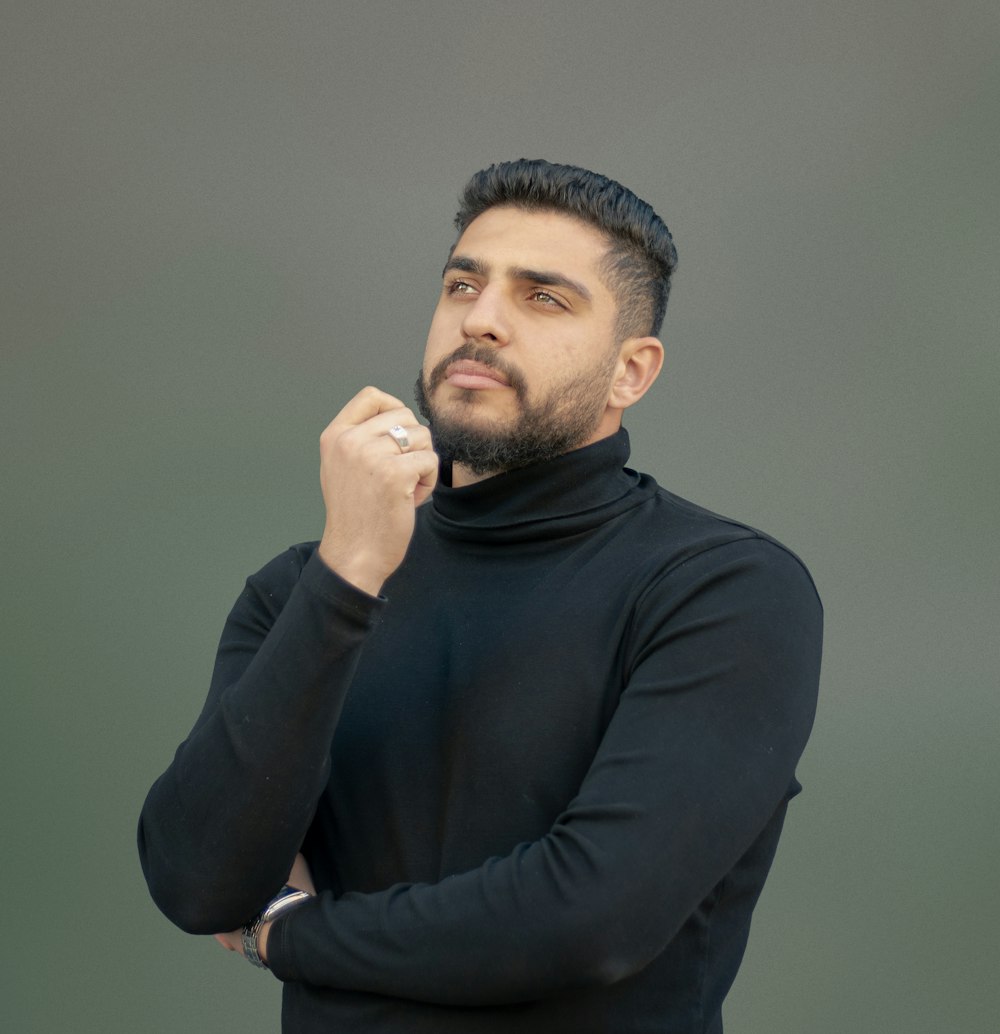 a man wearing a black turtle neck sweater