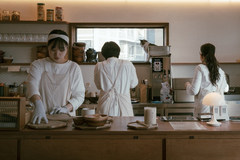 a group of women standing in a kitchen preparing food