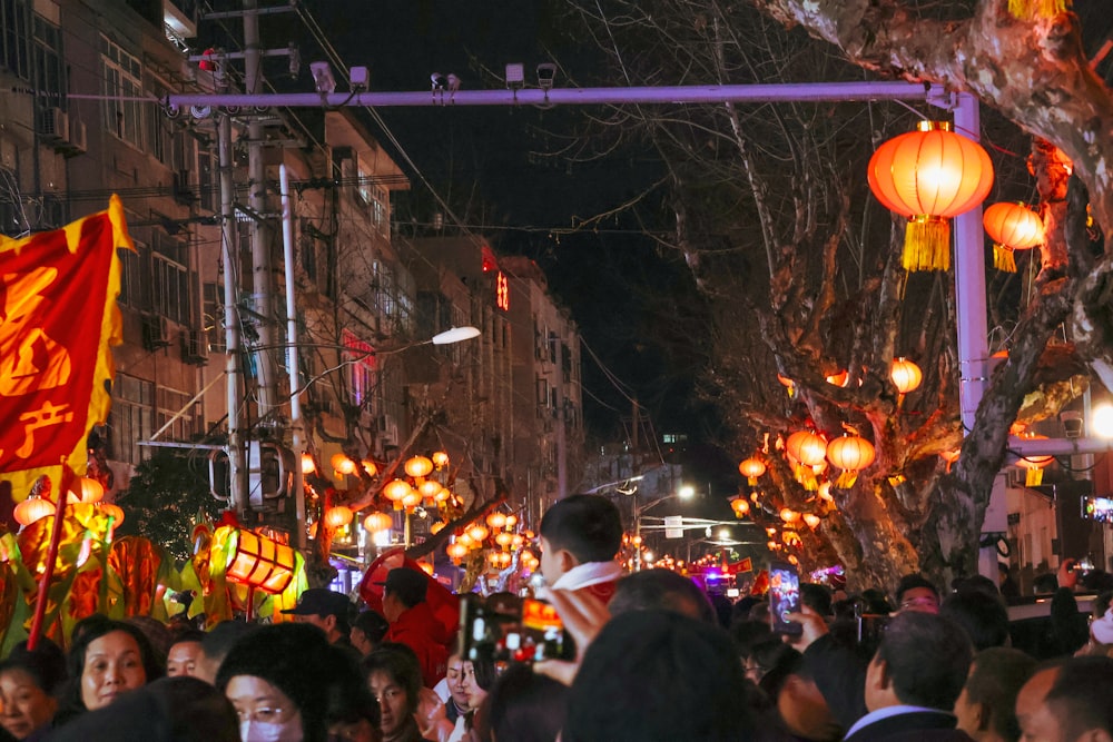 a crowd of people walking down a street at night