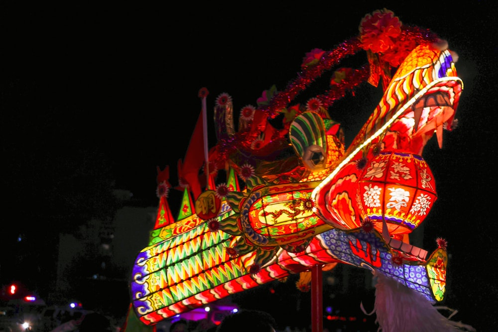 a carnival float lit up at night with colorful lights