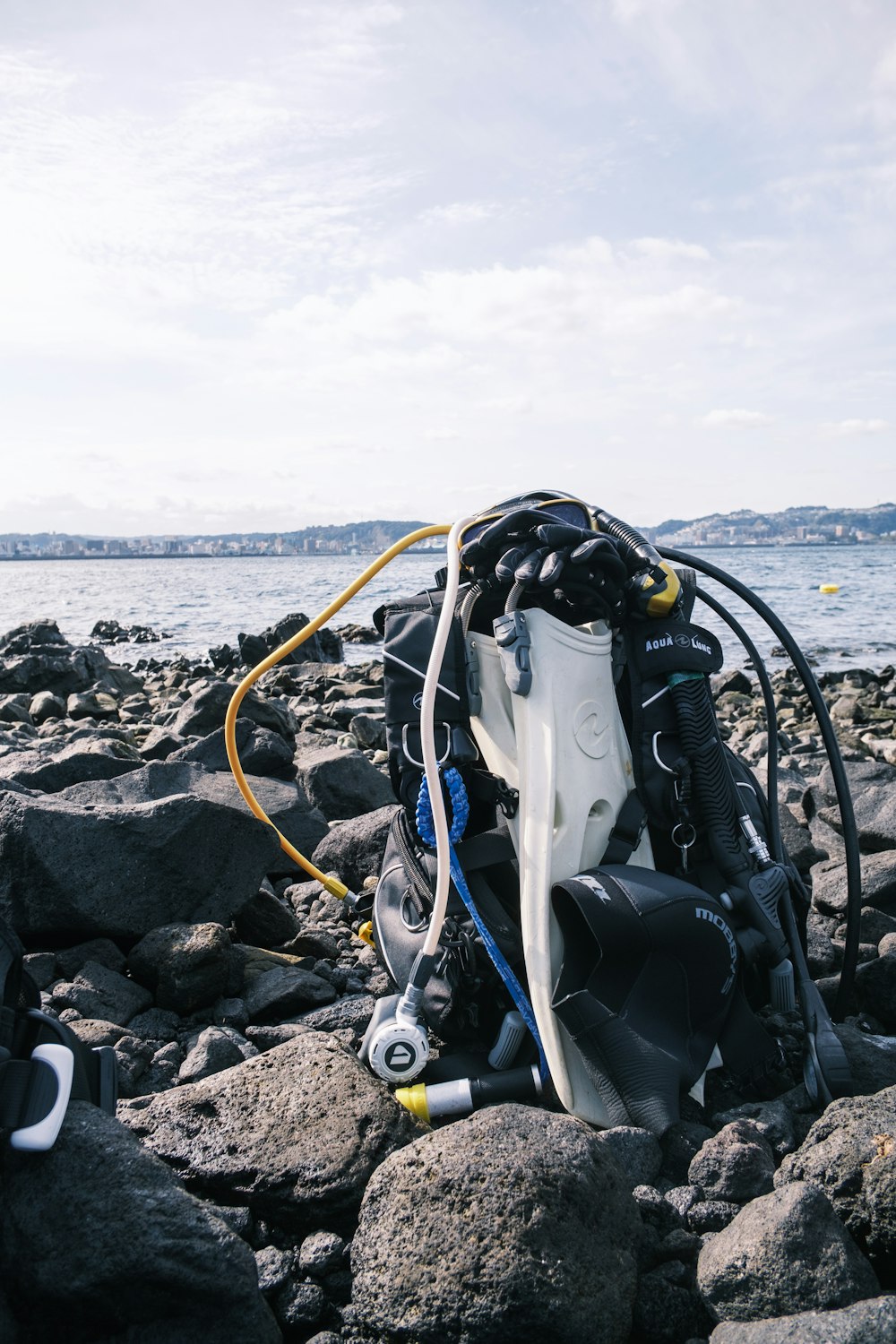 a bunch of scuba gear on a rocky beach