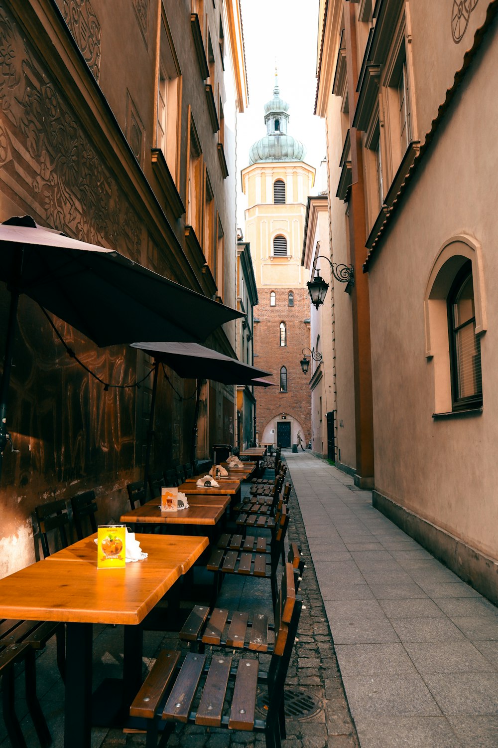 a row of tables with umbrellas on the side of a street