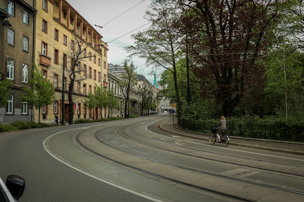 a man riding a bike down a street next to tall buildings