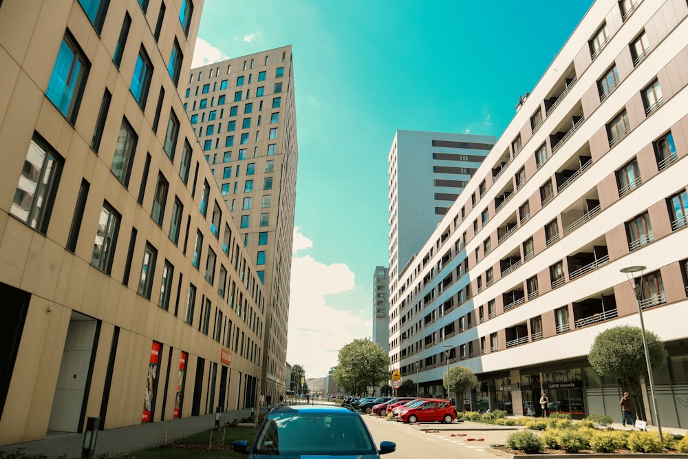 a blue car parked in front of a tall building