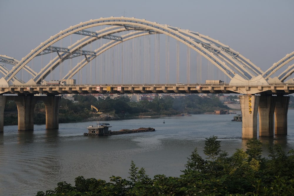 a large bridge over a river with a boat on it